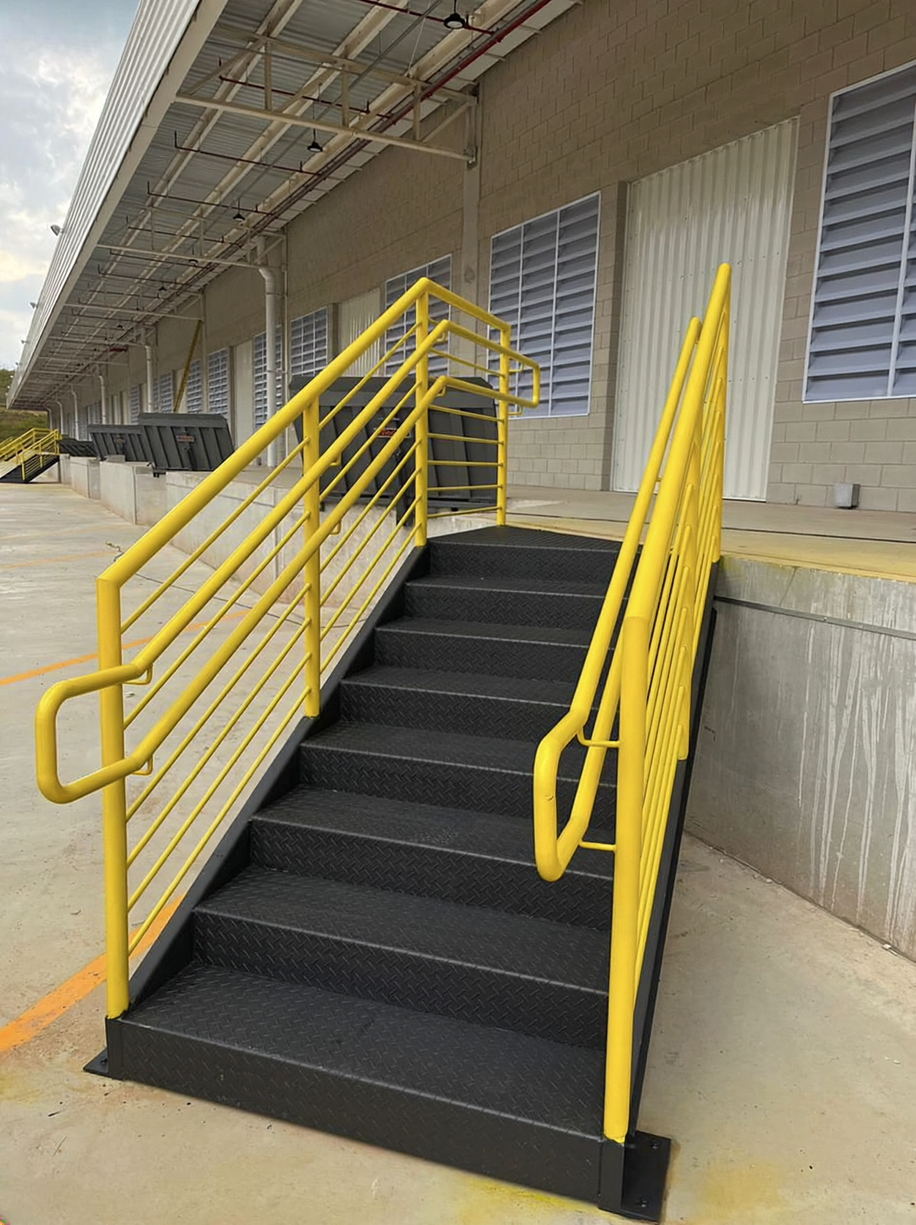 Escada industrial amarela instalada em galpão